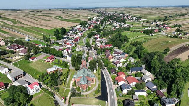 Suloszowa village in Krakow County. Aerial drone view of growing grain in the fields. Beautiful village with houses and fields in Poland. Village in the middle of the field from drone aerial view.