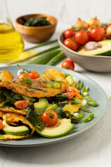 Pancakes with seaweed. Served on a plate with avocado and tomatoes.