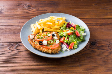 Breaded pork chop in tomatoes. Served with olives and feta cheese.