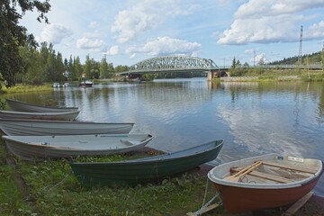 View of lake Vanajavesi with rowing boats on shore and railway bridge in the background in summer,...