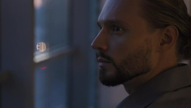 Pensive thoughtful businessman at evening office thinking problem solution idea hesitating pondering contemplating calm looking at city view look at office window business man male entrepreneur think