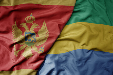 big waving national colorful flag of gabon and national flag of montenegro .