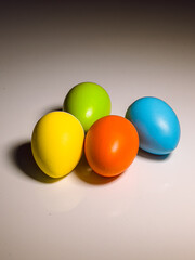 Photo of Easter eggs painted in a basic color palette, placed on the kitchen table.