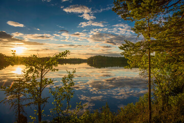 sunset over lake in Sweden framed by trees