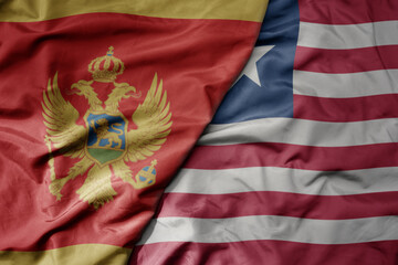 big waving national colorful flag of liberia and national flag of montenegro .