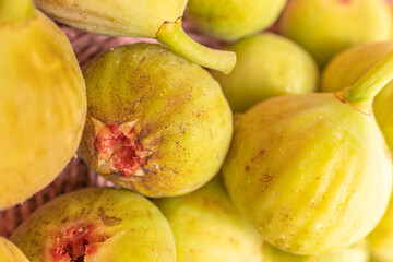 Selective focus of organically grown figs in a wicker basket, close-up view