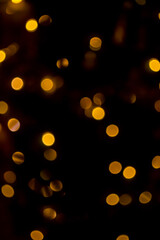 Yellow circles on a black background. Golden bokeh. Gold highlights on black. Yellow mugs in the dark.