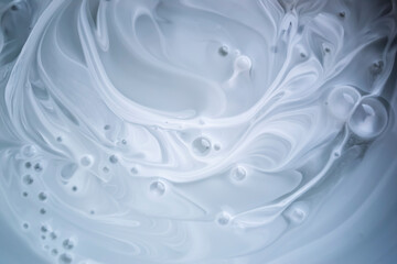 White paint with bubbles. The mixing of the paint is white and gray color. Shades of gray on white are abstraction,