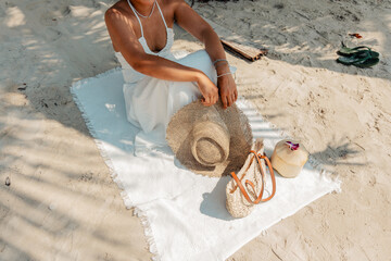 Relaxing at the beach,Woman sitting on beach with hat and bag and coconut