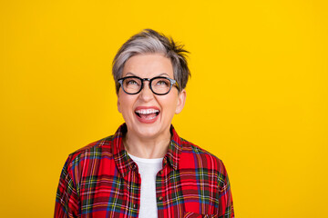 Portrait of funky overjoyed person look up empty space laugh have fun isolated on yellow color background