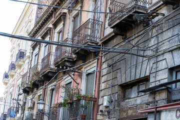 Fototapeta na wymiar A row of old buildings with a lot of wires hanging from the roof