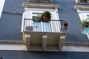 A balcony with a blue door and a white railing