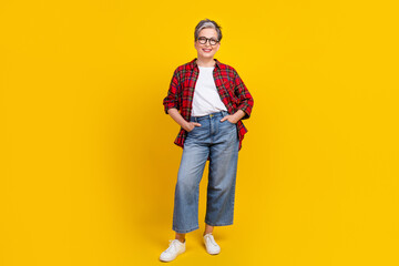 Full size photo of positive nice aged person put hands pockets posing empty space isolated on yellow color background