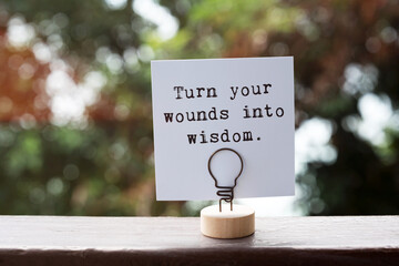 Paper note with inspirational quotes turn your wounds into wisdom