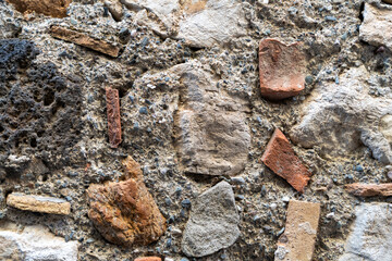 A wall made of stone and bricks with a few pieces missing