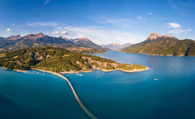 Summer aerial view of Serre-Poncon Lake with Chanteloube Bay and its submerged viaduct. Durance Valley with Grand Morgon peak in Hautes-Alpes (Alps), France