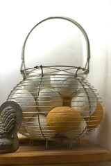 A metal basket contains fresh eggs, showing a rustic and homely style.