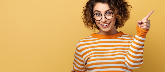 Confident Woman in Glasses Gesturing Upwards with a Pointing Finger - obrazy, fototapety, plakaty