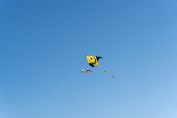 A yellow kite is flying in the sky