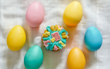 Fototapeta na wymiar Easter colored eggs and Easter cakes on a white tablecloth