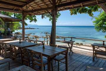 A beachside restaurant with tables and chairs overlooking the ocean