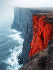 A cliff with a red rock on it - obrazy, fototapety, plakaty