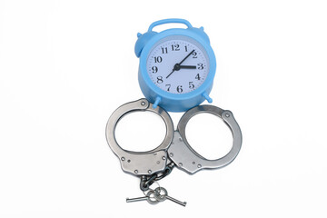 Zatrzymać czas, stalowe policyjne kajdanki obok zegara