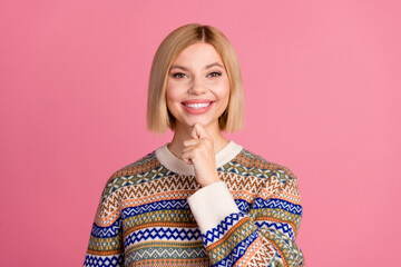 Portrait of toothy beaming woman with bob hairdo dressed print sweater think business finger on chin isolated on pink color background