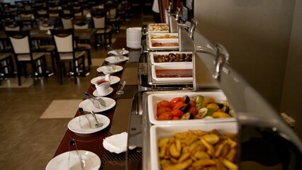 Catering buffet with heated trays ready to serve. Line with trays of food on a buffet table. Meals...