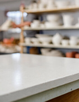 Empty table in ceramic workshop and local interior, pottery and small ceramic arts workshop, crafts or creative startup studio. Empty workstation of an art room for craft, painting or clay molding cla