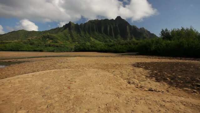 Damp shore with Hawaiian mountains in distance