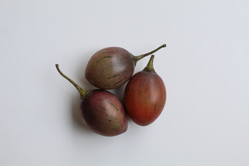 Tamarillo or Solanum betaceum fruit, three pieces. Isolated on white background. Flat lay or top view