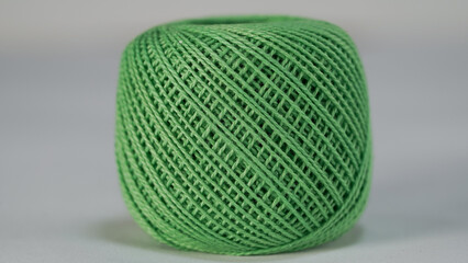 spool of green thread on a white background, close-up