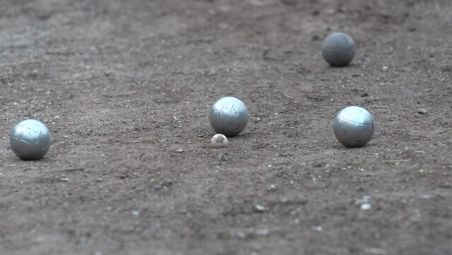 Petanque ball boules bowls on a dust floor, photo in impact, Game of petanque on the ground