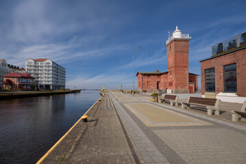 Fototapeta na wymiar LIGHTHOUSE AND PROMENADE - Stylish buildings in the port district