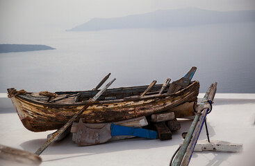 Weathered boat resting on Santorini rooftop, copy space.
