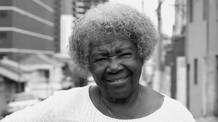 Joyful Expression of a Black Senior Woman in Her 80s, Portrait in Black and White standing in...