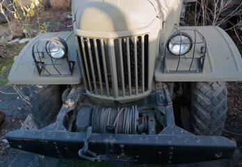 The front of a military truck with a cable on the bumper