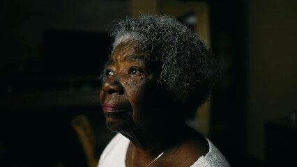 Meditative senior African American elderly lady with gray hair close-up face with contemplative...