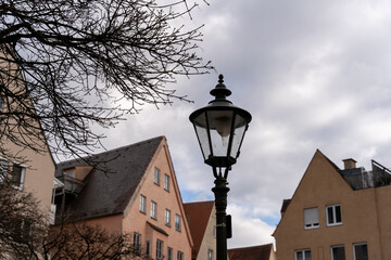 A street lamp is lit up in front of a row of houses