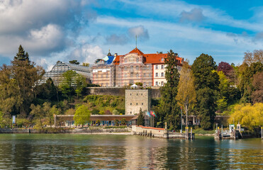Fototapeta premium Lovely panoramic view of the medieval Comturey tower and the habour of the famous island Mainau in Lake Constance (Bodensee), Germany. Above are the Teutonic castle with the palm house.