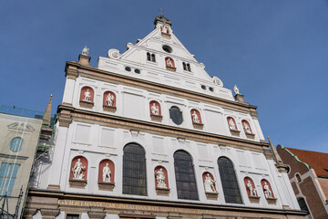A large white building with red accents and a blue sky in the background