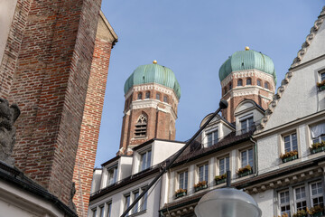 A cityscape with two tall green domes on top of a building