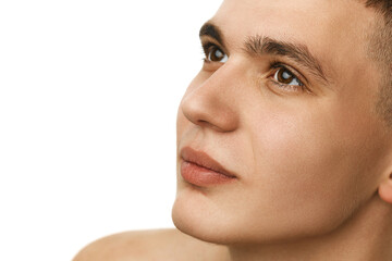 Close-up portrait of handsome young guy with smooth, clear face, brown eyes and short hair isolated...