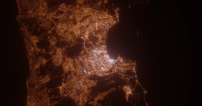 Baku (Azerbaijan) aerial view at night. Top view on modern city with street lights. Camera is zooming out, rotating counterclockwise. Vertical video. The north is on the left side