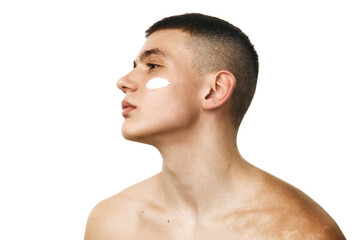 Profile view portrait of handsome young man standing shirtless, taking care after skin with...