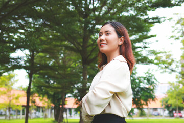 Portrait of a happy Asian woman smiling in an outdoor garden. health insurance, health care. copy space