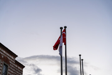 A red and white flag is flying on a pole