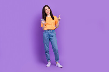 Full body length photo of business woman pointing empty space actual trends in tik tok using smartphone isolated on purple color background