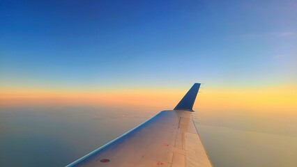 Aerial View of Airplane Wing at Sunrise, High Altitude Flight Perspective